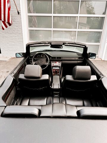 Interior of the 1995 Mercedes E320 Cabriolet from above &mdash; black leather front and rear seats with the top down
