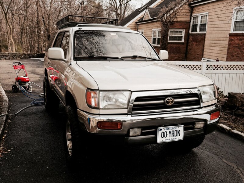 1997 Toyota 4Runner in white with a roof rack and Connecticut Classic Vehicle plates, parked in a residential driveway