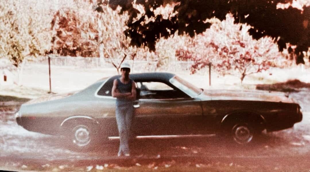 A young Tim Young leaning on his first car, a 1973 Dodge Charger SE, in 1983
